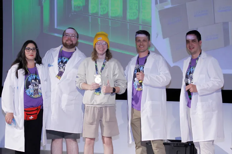 James Young receiving the 2025 Uber Badge on stage at BSides Tampa