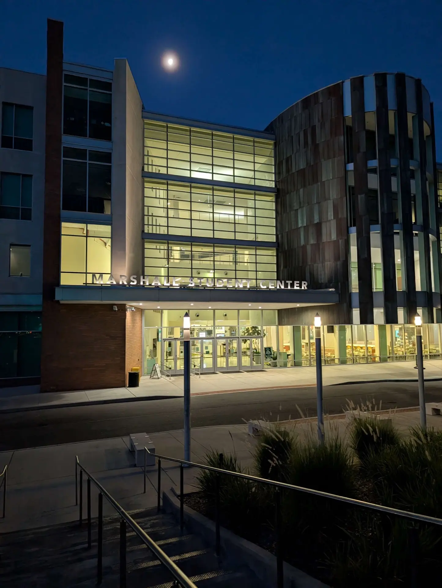 Night view of the USF Marshall Student Center main entrance, with the illuminated 'Marshall Student Center' sign above the glass doors